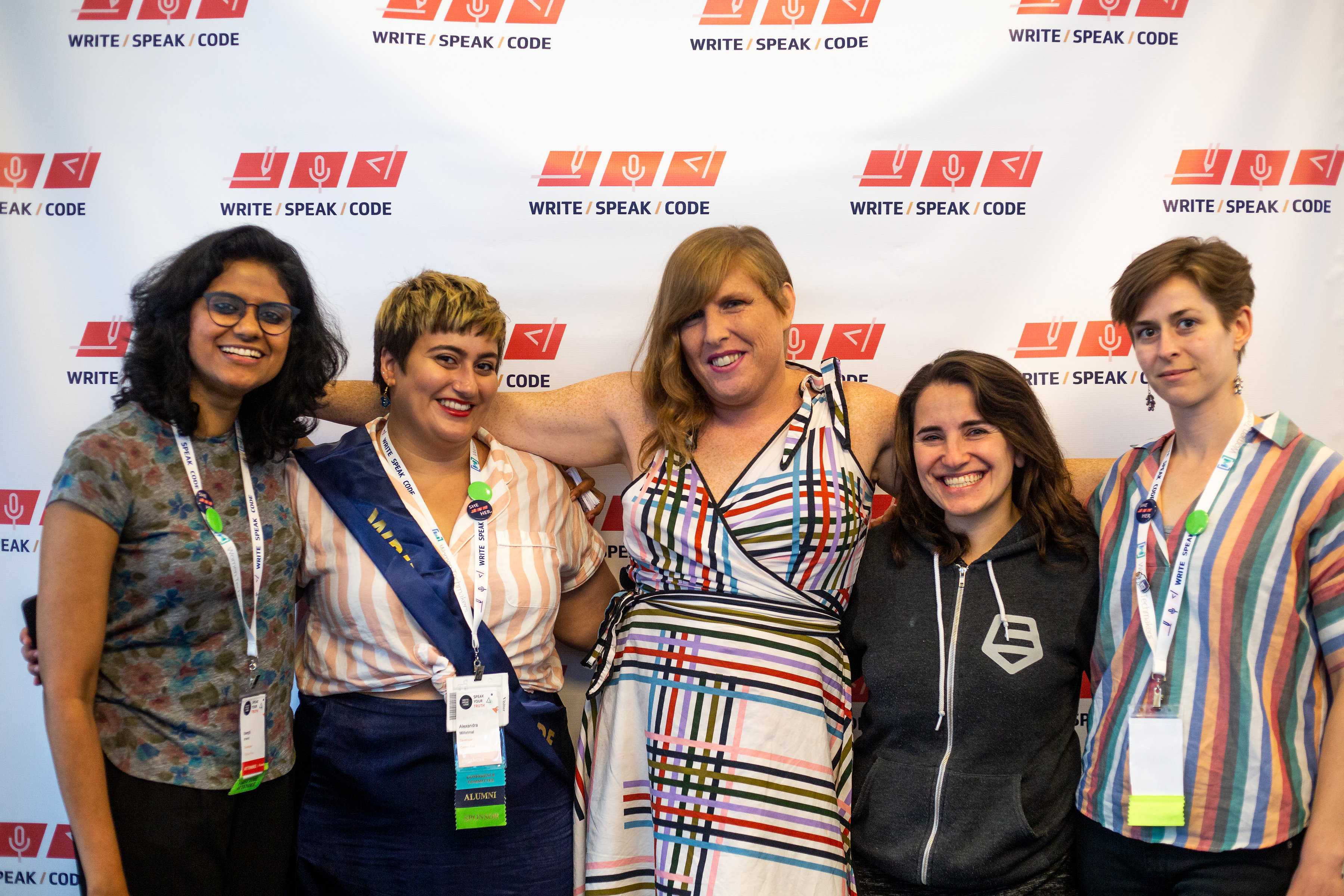 2018 conference-goers pose for a photo together in front of the Write Speak Code banner